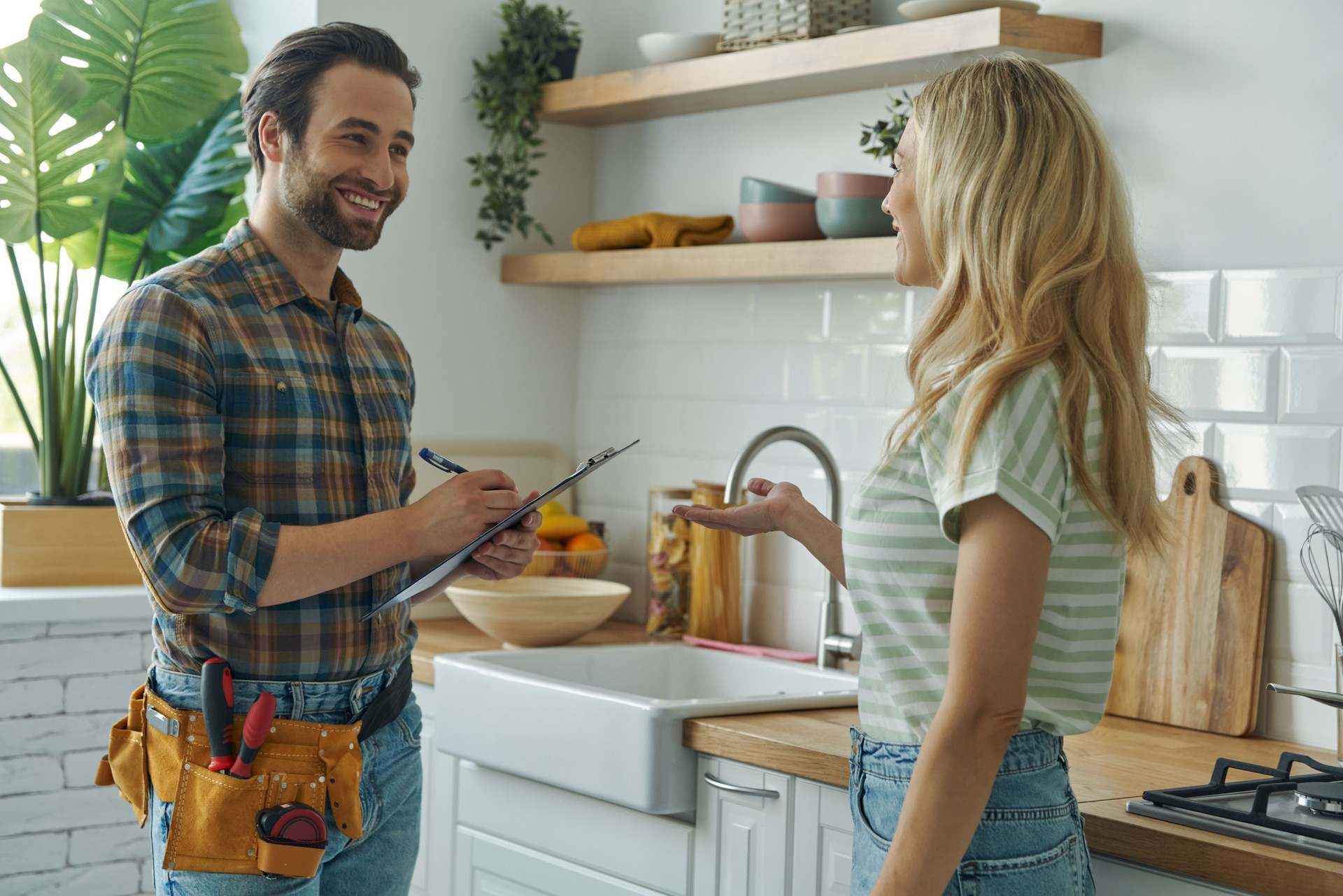 Beautiful young woman talking to male plumber