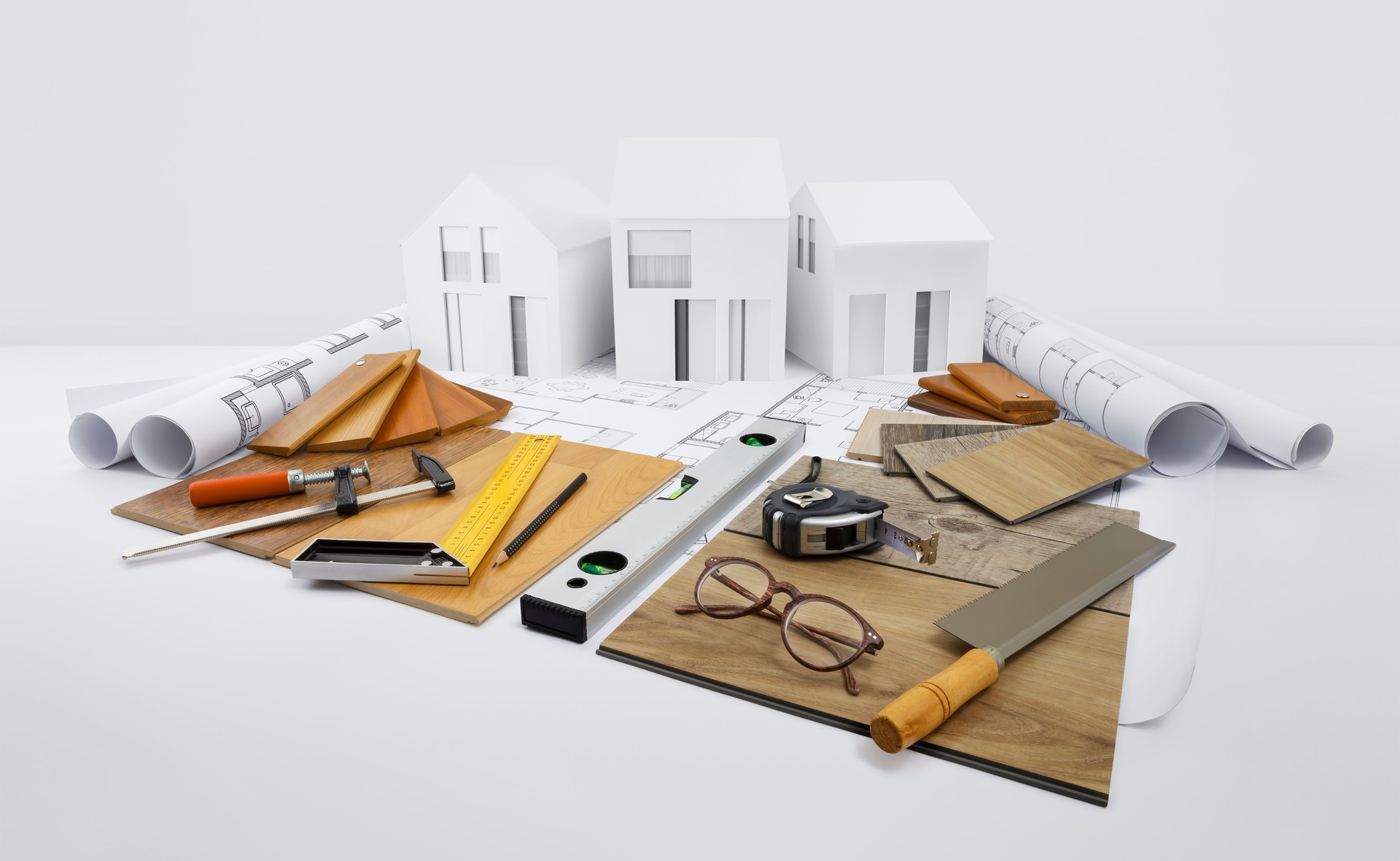 samples of wooden flooring, samplers of laminates, tiles and baseboards with carpenter tools on blueprint with model house, interior design, finishing materials shop, planning, sale and installation